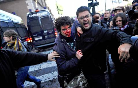 El ex diputado italiano del partido Refundación Comunista, Francesco Caruso, ayuda a un manifestante herido.