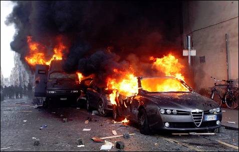 Un coche arde como consecuencia de los enfrentamientos entre los manifestantes y la policía.