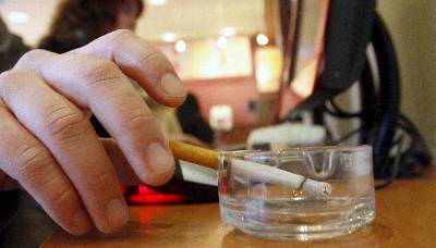 Un hombre fuma un cigarrillo en una cafetería.. EFE/Archivo