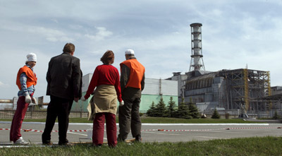 Un grupo de trabajadores observa el reactor número 4 de Chernóbil, cubierto por un sarcófago de época soviética, el pasado 19 de abril.