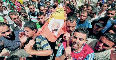 Militantes de Fatah trasladan el cadáver de uno de los jóvenes palestinos muertos ayer por disparos de la marina israelí.