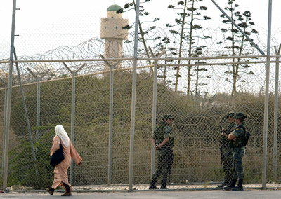Una mujer pasa por delante de la valla que separa Marruecos de la ciudad autónoma de Melilla.AFP