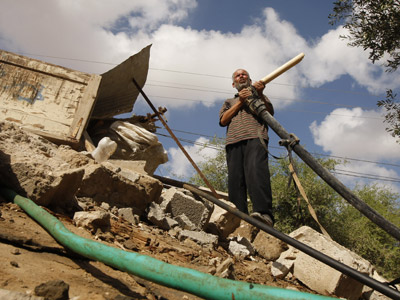 Un campesino palestino inspecciona el pozo de agua destruido por un ataque israelí en Rafah (Gaza).