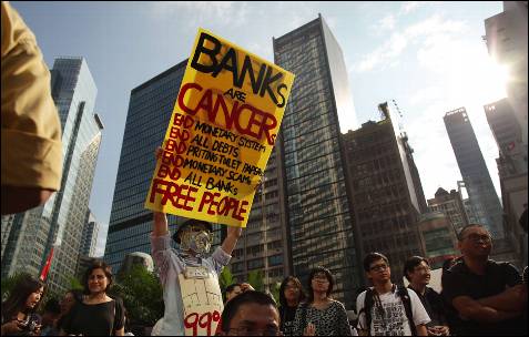 Un manifestante porta un cartel contra el sistema bancario en Honk Kong.-