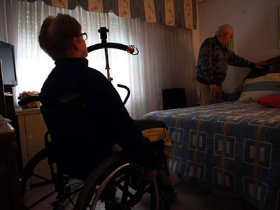 Juan Francisco, de 75 años, prepara la cama para su mujer, Ramona, de 68 y con discapacidad.-