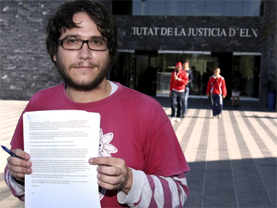 Adrián Vaíllo, del Movimiento Antimilitarista Tortuga, muestra el escrito que ha presentado en el registro de los juzgados de Elche.-EFE/Morell