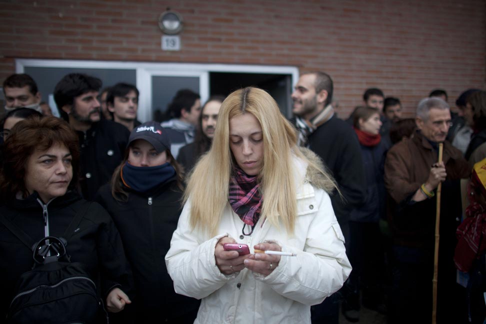 Azucena escribe un mensaje en su teléfono móvil durante la protesta para evitar el desahucio en Madrid.