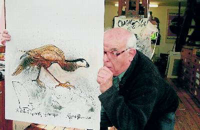 El ilustrador Ralph Steadman sostiene un lienzo con la especie Guadalupe Caracara. Ceri Levy