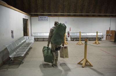 Un soldado estadounidense portando sus pertenencias en una base aérea en Bagdad antes de abandonar Irak a bordo de un avión militar. Lucas Jackson / ap