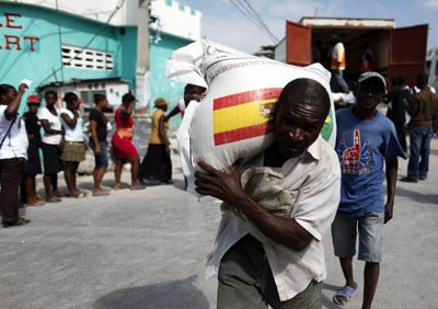 Un hombre carga un saco de la ayuda española en Puerto Príncipe (Haití).-