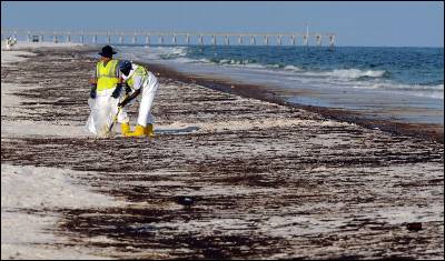 Dos operarios limpian el crudo en una playa de Florida, en junio del año pasado. AP