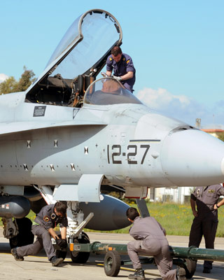 Militares españoles preparan un caza F-18 en la base italiana de Decimimannu.- MARIO ROSAS (AFP)