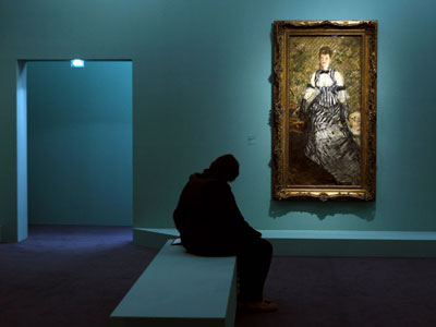 Una visitante de la exposición, junto al cuadro Dama en traje de noche'. afp