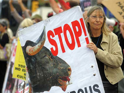 Una mujer sostiene una pancarta en contra del maltrato a los toros. MANU FERNÁNDEZ