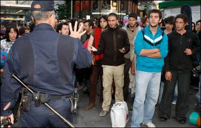 Agentes de Policía frente a un grupo de jóvenes presentes en el acampada de la Puerta del Sol de Madrid.