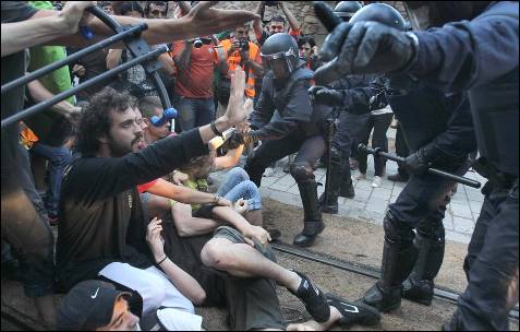 Varios mossos d'Esquadra intentan apartar a varios jovenes durante la concentración que estan realizando más de 2.000 'indignados' alrededor del Parque de la Ciutadella de Barcelona intentando bloquear los accesos al Parlament.