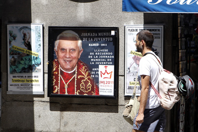 Un hombre, ante un cartel de la JMJ en Madrid.