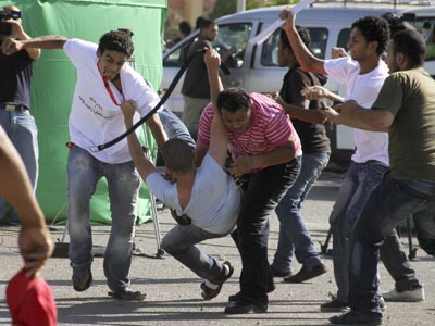 Seguidores y oponentes de Mubarak se enfrentan violentamente en el exterior del tribunal poco antes del inicio del juicio, ayer. Ahmed Ali / ap