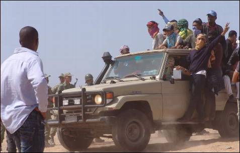 Marroquíes subidos en una 'pick-up' se dirigen, ante la pasividad de los militares, hacia una explanada en la que se producía el enfrentamiento.