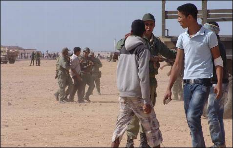 Los soldados de Rabat charlan con marroquíes que portan piedras en sus manos.