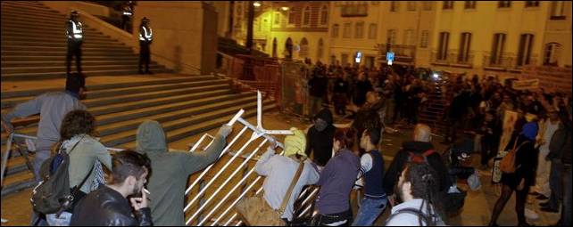 Manifestantes tratan de tumbar una barrera durante una manifestación por el presupuesto presentado por el Gobierno ante el Parlamento - EFE