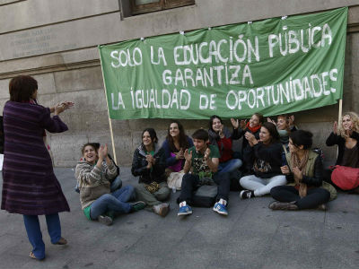 Una mujer aplaude a un grupo de estudiantes que protestan frente a un colegio de Madrid. REUTERS/Andrea Comas
