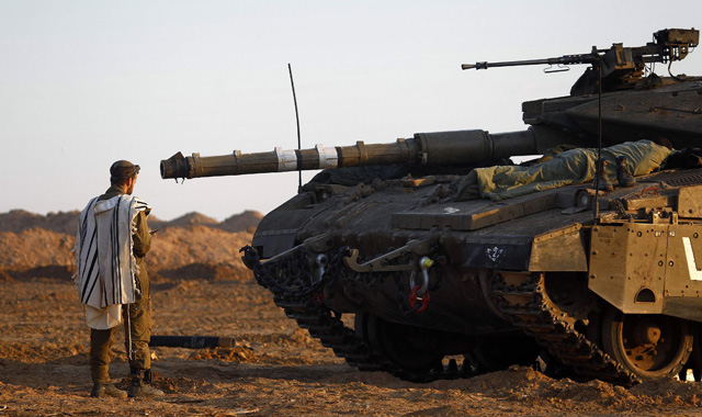 Un soldado israelí reza delante de su tanque.