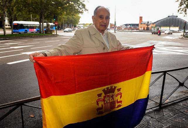 David Solomon posa junto a la bandera republicana frente a la Estación de Atocha (Madrid)