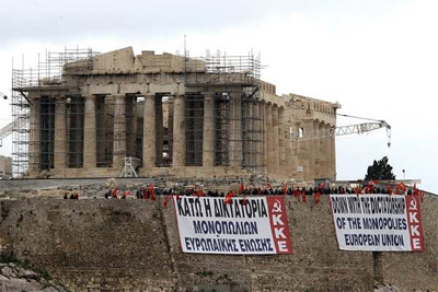 Miembros del Partido Comunista Griego despliegan dos pancartas en la Acrópolis de Atenas. -