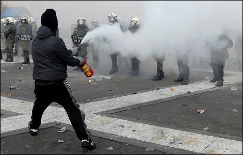 Un manifestante se enfrenta a las fuerzas griegas.