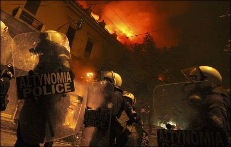 Los antidisturbios avanzan entre edificios en llamas.