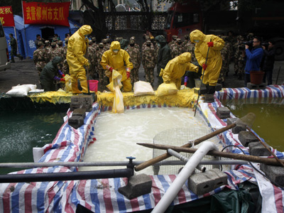 Operarios chinos limpian aguas contaminadas.