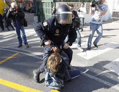 Un agente de policía forcejea con un joven. -