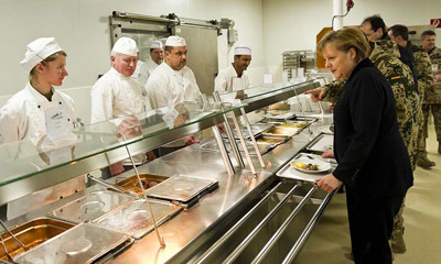 Merkel pasa con una bandeja para comer en la base militar de Mazar, en Afganistán.
