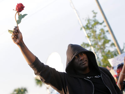 Un manifestante levanta una rosa para pedir justicia por Martin.
