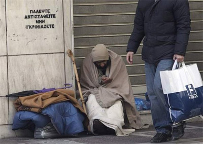 Un indigente pide limosna en una calle del centro de Atenas.-EFE