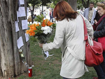 Una mujer deposita flores en el lugar donde el jubilado griego Dimitris Christoulas se suicidó en abril. EFE