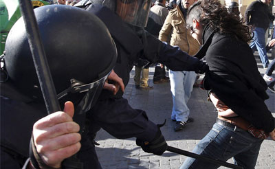 Una joven es golpeada por la policía durante las protestas de los estudiantes valencianos contra los recortes en educación.- AP