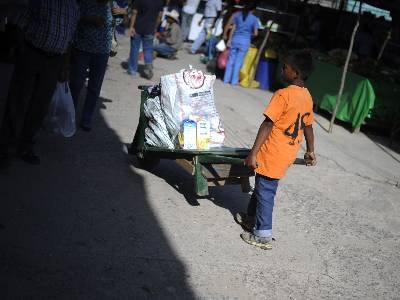 Un niño lleva verduras en una carretilla al mercado en el que trabaja en Tegucigalpa. REUTERS/Jorge Cabrera