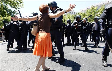 Una manifestante se acerca a los antidisturbios y discute con un agente - AFP