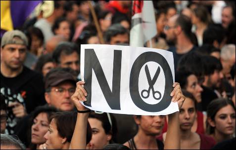 Manifestantes, con un cartel contra los Recortes del Gobierno de Rajoy.- AFP