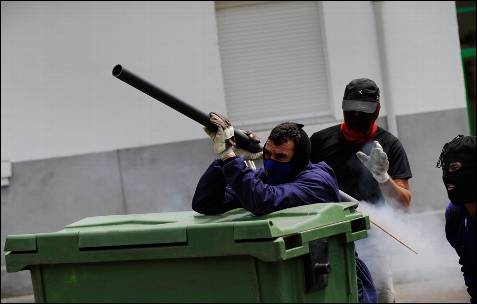 Un grupo de mineros lanza un cohete en las calles de Ciñera - REUTERS