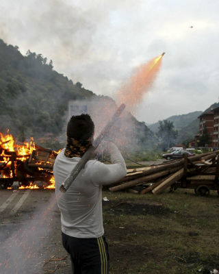 Un Mineros lanzan cohetes desde la barricada colocada esta mañana en el pozo Santiago de Aller.