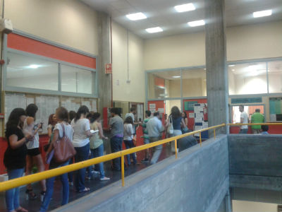 Algunos estudiantes esperan turno en la secretaría de la Facultad de Ciencias de la Información de la Universidad Complutense de Madrid.