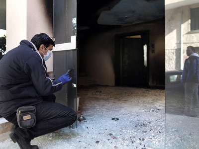 Un policía examina los daños a un edificio atacado con bombas incendiarias el pasado domingo en Atenas.