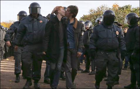 Activistas por los derechos de los homosexuales se besan mientras son detenidos por la policía en San Petersburgo.
