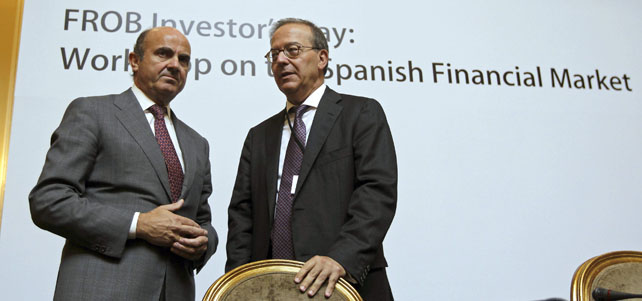El ministro de Economía, Luis de Guindos, acompañado por el director general del Fondo de Reestructuración Ordenada Bancaria (FROB), Antonio Carrascosa.