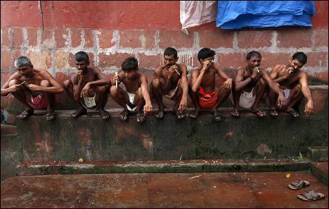 Varios jornaleros se cepillan los dientes con ramitas de neem, en las orillas del río Ganges, en Calcuta.