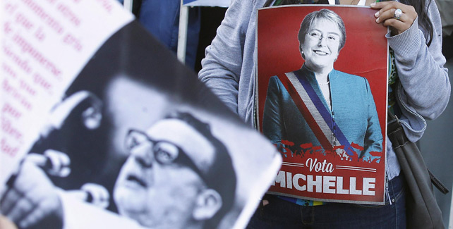 Un simpatizante de la candidata presidencial Michelle Bachelet posa con un poster junto a una imagen del expresidente Salvador Allende.- ELISEO FERNÁNDEZ (REUTERS)