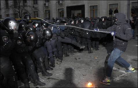 Una manifestante ataque el cordón policial en Kiev.